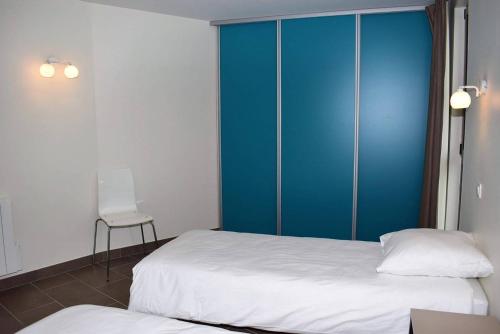 1 Schlafzimmer mit 2 Betten und einem blauen Schrank in der Unterkunft Maison neuve de plain-pied avec WIFI classée 3 étoiles à Trégastel Ref 466 in Trégastel
