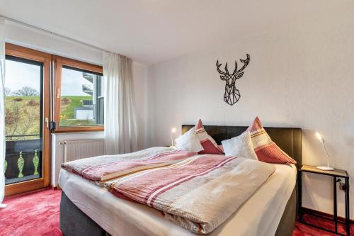 una camera da letto con un letto con una testa di cervo sul muro di Fewo Panorama - Haus Sommerberg a Baiersbronn