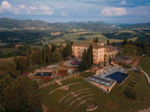 - une vue aérienne sur un bâtiment avec un court de tennis dans l'établissement Castello di Casole, A Belmond Hotel, Tuscany, à Casole dʼElsa