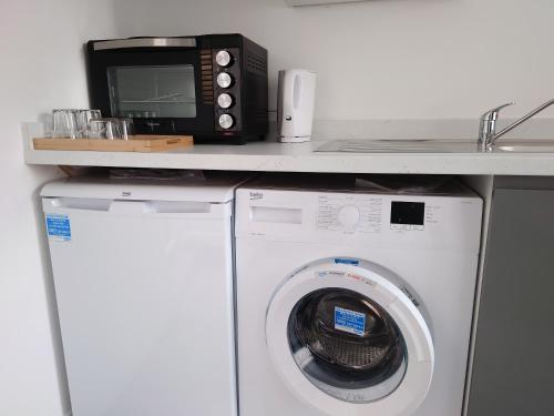 a microwave sitting on top of a washing machine at Centra Station in London