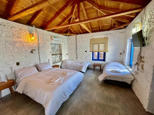 a bedroom with two beds and a wooden ceiling at Rocksecret Edge in Kalamata