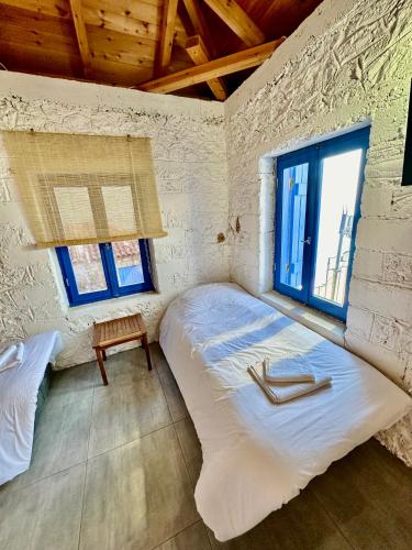 a bedroom with a large bed and two windows at Rocksecret Edge in Kalamata