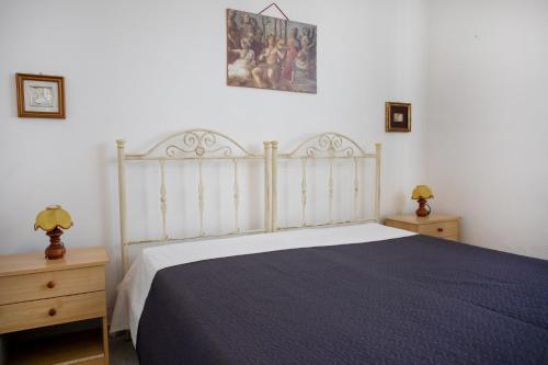 1 dormitorio con 1 cama grande y 2 mesitas de noche en Villetta Oasis, en Punta Prosciutto