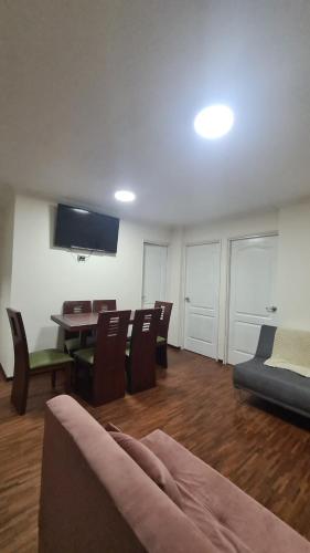 uma sala de estar com um sofá, uma mesa e cadeiras em Hermoso departamento en norte de Quito em Quito