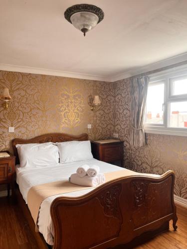 a bedroom with a bed with two towels on it at Rose Tor Hotel in Llandudno