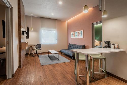 a living room with a table and a couch at City Express Suites by Marriott Queretaro in Querétaro