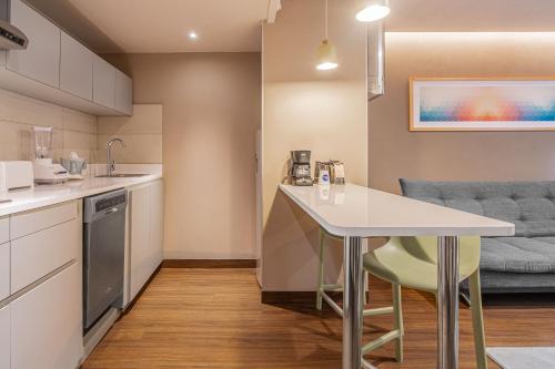 a kitchen with a table and a couch at City Express Suites by Marriott Queretaro in Querétaro