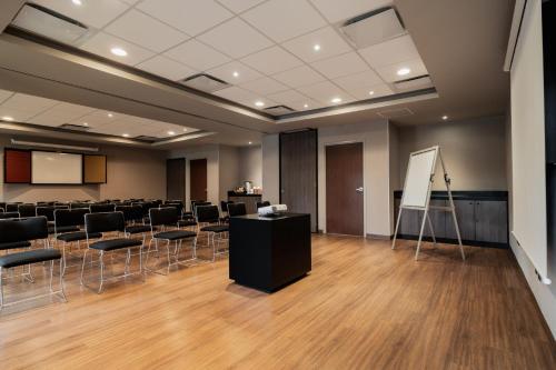 a conference room with chairs and a podium at City Express Suites by Marriott Queretaro in Querétaro