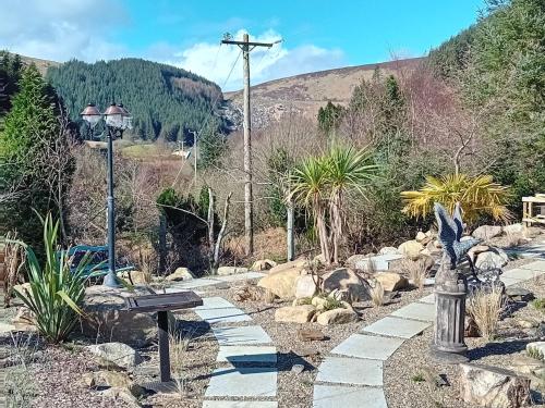a garden with a bench and a street light at Clarisses Cottage in Laragh
