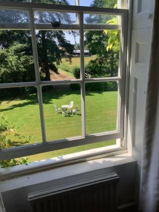 a window with a view of a green yard at Church house in Claines