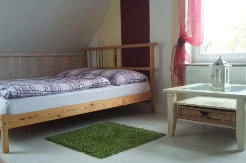 ein kleines Schlafzimmer mit einem Bett und einem Tisch in der Unterkunft Ferienwohnung in Thurnau in Thurnau