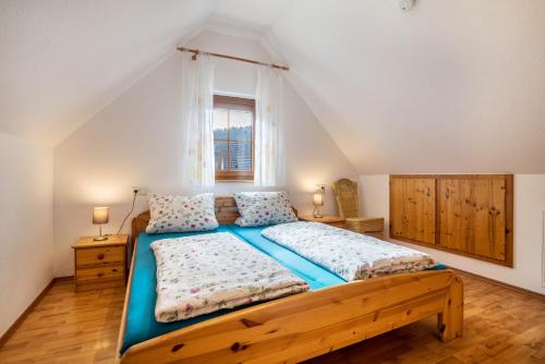 sypialnia z drewnianym łóżkiem i oknem w obiekcie Ziegelhof w mieście Schuttertal