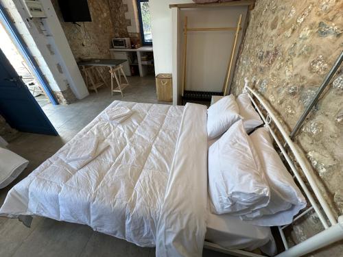 a bedroom with a bed with white sheets and pillows at Rocksecret Edge in Kalamata