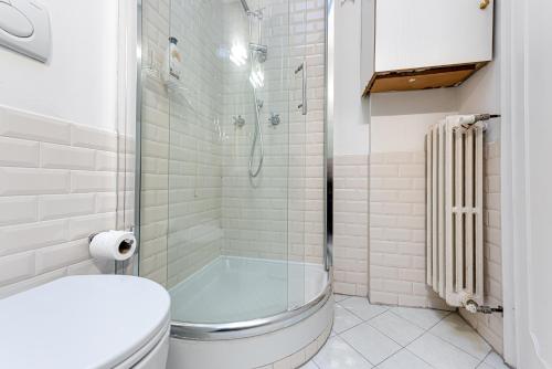 uma casa de banho branca com um chuveiro e um WC. em Casa Pantanella a Palazzo Vecchio em Florença