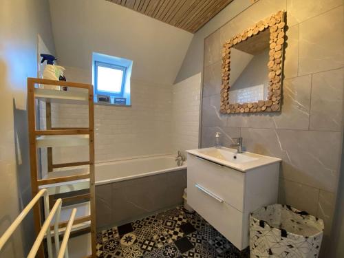 ein Badezimmer mit einem Waschbecken und einer Badewanne in der Unterkunft Maison avec jardin, à 600m de la mer à TREGASTEL Réf - 57 in Trégastel