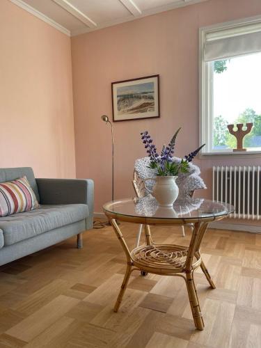 a living room with a couch and a table with flowers on it at Familjehuset Sunnemo in Sunnemo
