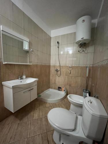 a bathroom with a toilet and a sink and a tub at Bega's Apartment in Golem, Durrës in Golem