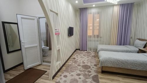 a small room with two beds and a mirror at Отель Чынгыз 2 in Osh