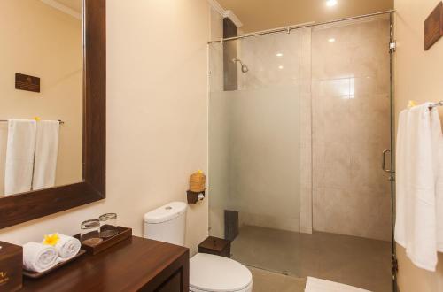 La salle de bains est pourvue d'une douche et de toilettes. dans l'établissement The Mudru Resort by Pramana Villas, à Ubud