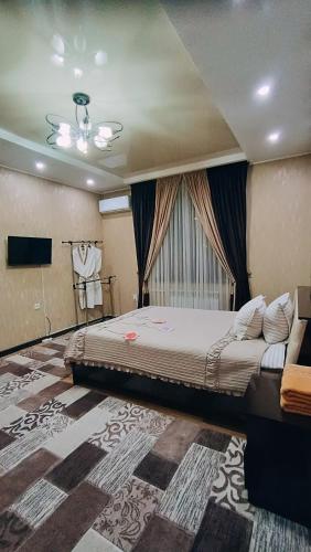 a bedroom with a large bed and a television at Отель Чынгыз 2 in Osh