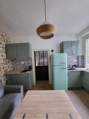 - une cuisine avec un réfrigérateur bleu dans la chambre dans l'établissement Charmant studio très calme en centre-ville, à Saint-Germain-en-Laye