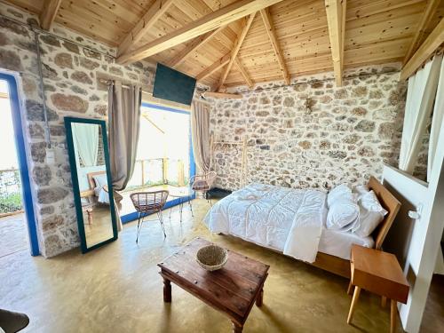 a bedroom with a bed and a stone wall at Rocksecret Edge in Kalamata