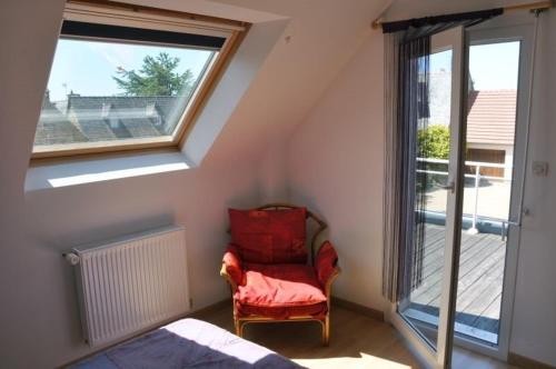 Zimmer im Dachgeschoss mit einem Stuhl und einem Fenster in der Unterkunft Belle villa 3 étoiles avec terrasse ensoleillée et protégée à TREGASTEL - Ref 63 in Trégastel