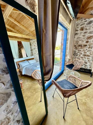 a mirror in a room with a bed and a chair at Rocksecret Edge in Kalamata