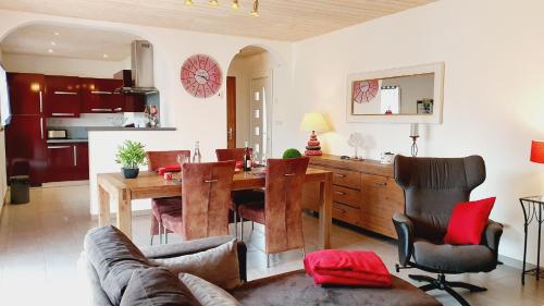 un salon avec une table et une salle à manger dans l'établissement Les Palmiers, à Penvénan