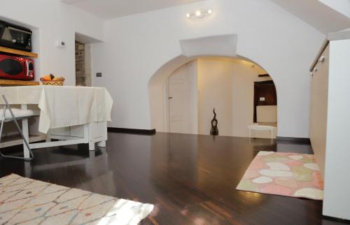a living room with a table and a white wall at La Petite Maison in Ruvo di Puglia