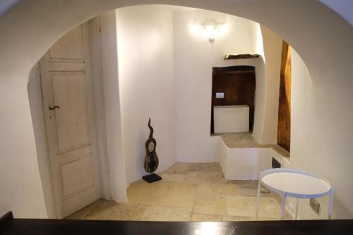 een hal met een tafel en twee stoelen en een deur bij La Petite Maison in Ruvo di Puglia