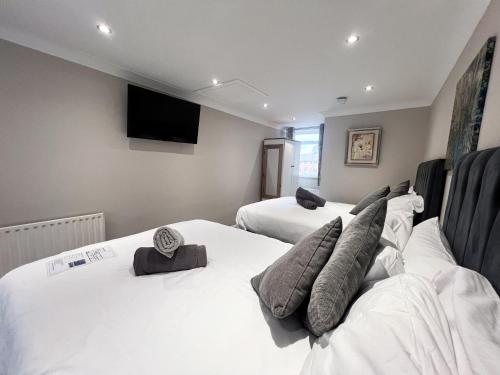 a room with three beds and a flat screen tv at Beldon House in Brigg