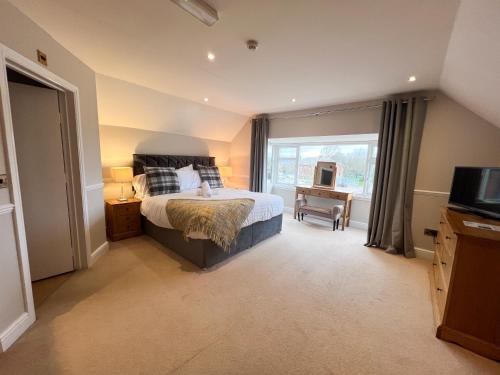 a bedroom with a bed and a tv and a window at Beldon House in Brigg