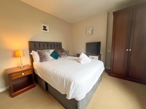 a bedroom with a bed with a nightstand and a television at Beldon House in Brigg