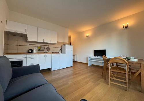 eine Küche und ein Wohnzimmer mit einem Sofa und einem Tisch in der Unterkunft Maison Linda - Ponte Milvio Apartment in Rom