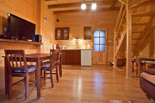 a kitchen and dining room with a table in a cabin at Domek w Krynicy z sauną in Krynica Zdrój