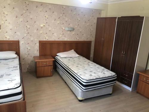 阿勒的住宿－Ortadoğu apart otel，一间卧室设有两张床和木制橱柜。