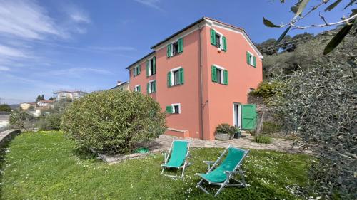 two chairs sitting in front of a building at Miralunga Villetta Rossa in Lerici