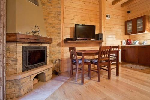 a dining room with a table and a fireplace at Domek w Krynicy z sauną in Krynica Zdrój