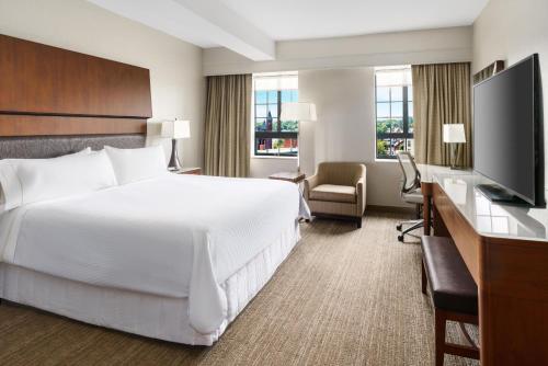 a hotel room with a bed and a flat screen tv at The Westin Portland Harborview in Portland