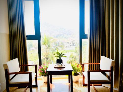 a room with two chairs and a table in front of a window at An's Home Hotel Vũng Tàu in Vung Tau