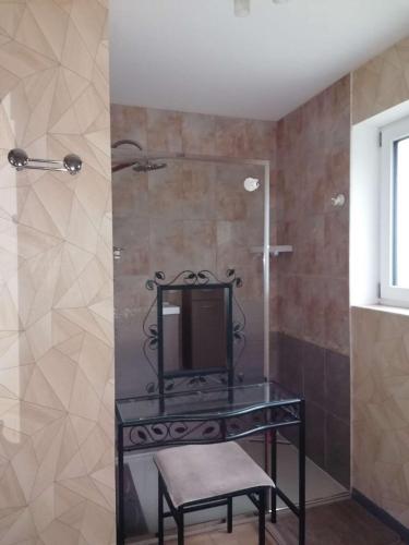 une douche avec une table en verre et une chaise dans une salle de bain dans l'établissement Villa en bois récente avec jardin, WIFI à 800m du centre de TREBEURDEN - Réf 668, à Trébeurden
