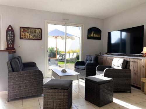 a living room with couches and a flat screen tv at Maison VUE MER, jardin, terrasse, WIFI, au SUD, à TREBEURDEN - Réf 663 in Trébeurden