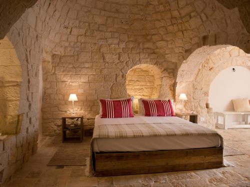 塞尔瓦迪法萨诺Nina Trulli Resort的一间卧室，石墙内有一张床
