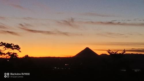 a sunset with a mountain in the background at VILLA SIMONE ARENAL French Ecolodge in Tilarán