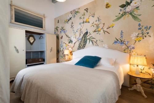 a bedroom with a white bed with flowers on the wall at 3 Apartamentos Independientes en Casa Palacio in San Fernando