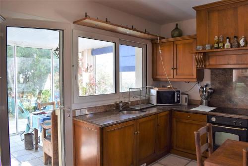 une cuisine avec un évier et un micro-ondes dans l'établissement Grande Maison VUE SUR MER 9 pers à Trébeurden - Réf 682, à Trébeurden