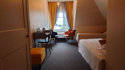 a hotel room with a bed and a table and chairs at Guesthouse Četri Vēji in Turkalne