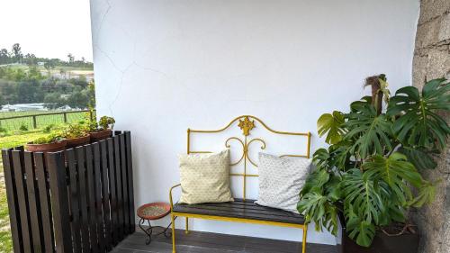 a bench sitting on a porch with plants at Quinta do Burgo - Nature Hotel in Amares