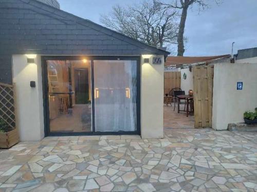 una casa con una gran puerta corredera de cristal en un patio en Studio avec terrasse, en Brest